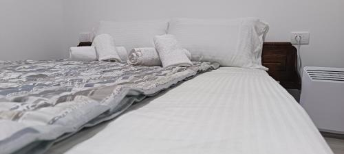 a bed with white sheets and pillows on it at Apartman Zlatibor in Čajetina