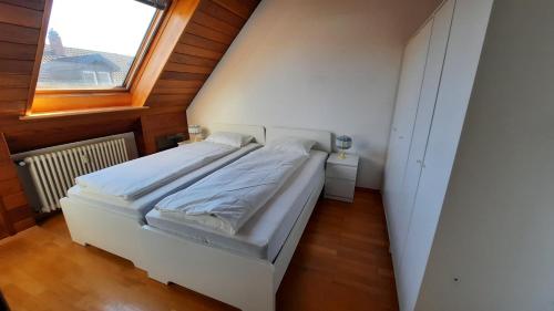 ein Schlafzimmer mit einem weißen Bett und einem Fenster in der Unterkunft Black Stone Apartments - Lörrach in Lörrach