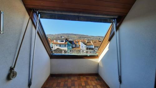 an attic hallway with a large window in a house at Black Stone Apartments - Lörrach in Lörrach