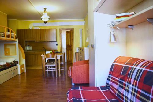 Una sala de estar con un sofá y una cocina. en 5 Minutes from Monterosa Ski, Small Cottage, en Gressoney-la-Trinité