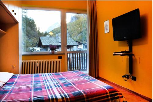 a bedroom with a bed and a large window at 5 Minuti da Monterosa Ski, Piccolo Cottage in Gressoney-la-Trinité