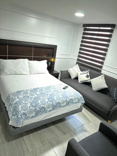 een slaapkamer met een bed en een bank bij Villa GyG in Mexico-Stad