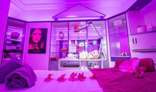 a pink room with a bed with pink lighting at Vital- und Wellnesshotel Albblick in Waldachtal