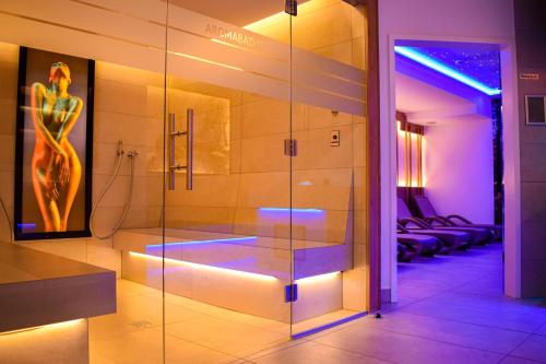 a glass shower in a bathroom with a picture of a woman at Vital- und Wellnesshotel Albblick in Waldachtal