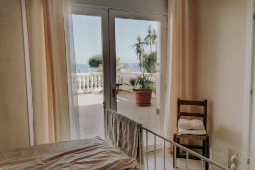 a room with a bed and a balcony with a view at Villa Soluna in Vélez-Málaga