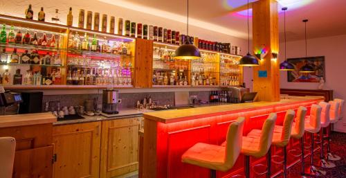 a bar with orange chairs in a restaurant at Vital- und Wellnesshotel Albblick in Waldachtal