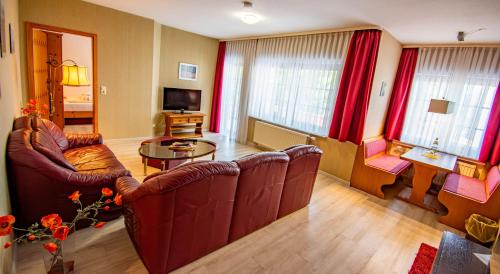a living room with two couches and a table at Vital- und Wellnesshotel Albblick in Waldachtal