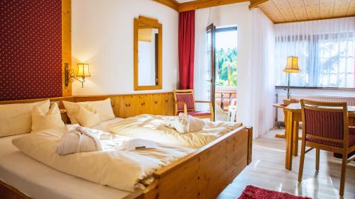 a bedroom with a large bed in a room at Vital- und Wellnesshotel Albblick in Waldachtal