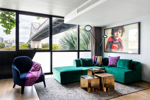 a living room with a green couch and a chair at Crystalbrook Vincent in Brisbane