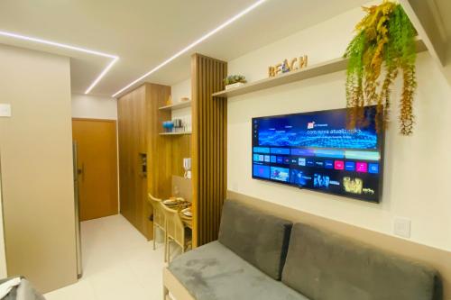 a living room with a television on a wall at Studio de Luxo em Muro Alto - Makia Beach A209 in Porto De Galinhas