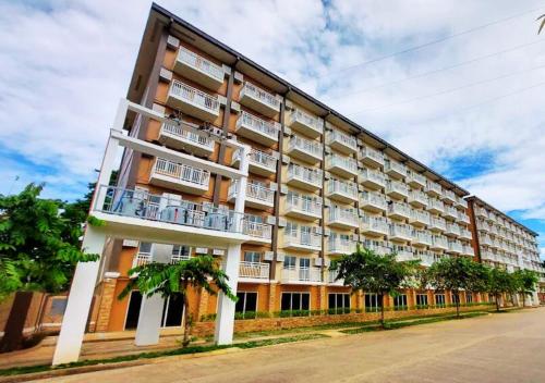a large building with palm trees in front of it at Best Pet-Friendly Condo Near Puerto Princesa Airport - B2 6Diamond in Puerto Princesa City