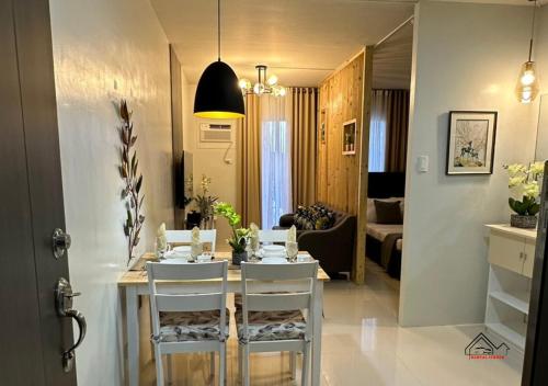 a dining room with a table and white chairs at Palawan 1BR Summer Get-away Deluxe with Balcony FREE Pool and Gym - T2 6 Diamond in Puerto Princesa City