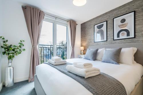埃普瑟姆的住宿－Cozy 3 Bedroom Terrace Cottage in Epsom，一间卧室配有一张大床和毛巾