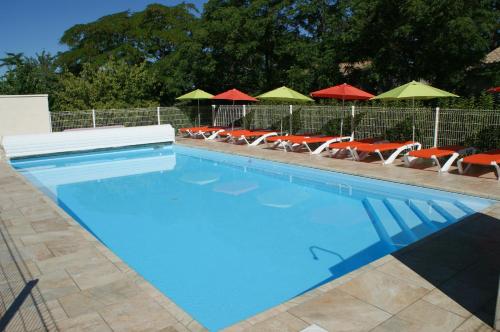 une piscine avec chaises et parasols dans l'établissement Chambres d'hôtes La Gardie, à Vias
