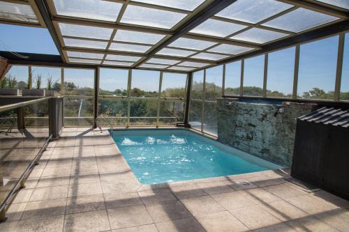 an indoor swimming pool with a glass roof at Vecchia Terra Apart Hotel in San Rafael