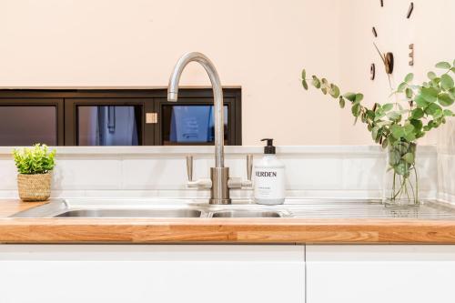 a kitchen sink with a bottle of soap on it at Cozy 3 Bedroom Terrace Cottage in Epsom in Epsom
