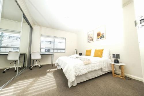 biała sypialnia z łóżkiem oraz 2 biurkami i krzesłami w obiekcie Sydney Ultimo 2bed,cls Broadway shopping,UTS,USYD w mieście Sydney