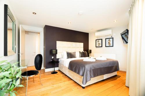 a bedroom with a large bed and a black wall at Modern City Apartments in London
