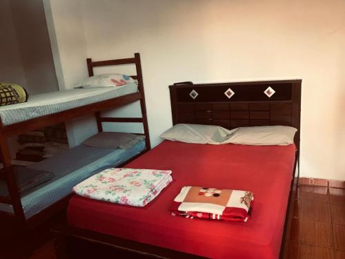 Zimmer mit 2 Etagenbetten und einem roten Bett in der Unterkunft Casa de Hospedagem Ave Maria 2 in Cachoeira Paulista