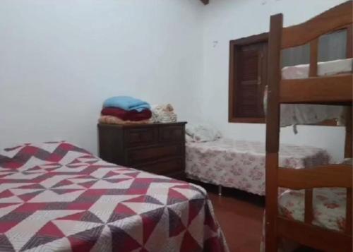 - une chambre avec un lit, une commode et des lits superposés dans l'établissement Pousada Claudia e Juliano, à São Gabriel