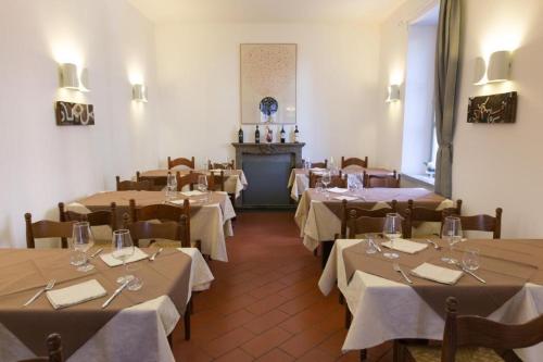 uma sala de jantar com mesas e cadeiras e uma lareira em Locanda La Pignatta em Arogno