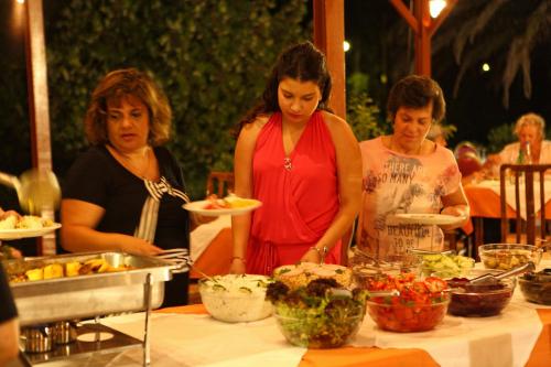 a group of women standing around a table with food at Pasiphae Hotel in Skala Kallonis