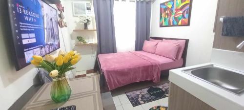 a small room with a table and a vase of flowers at JJMC HOMESTAY 22 With netflix and fast wifi in Manila
