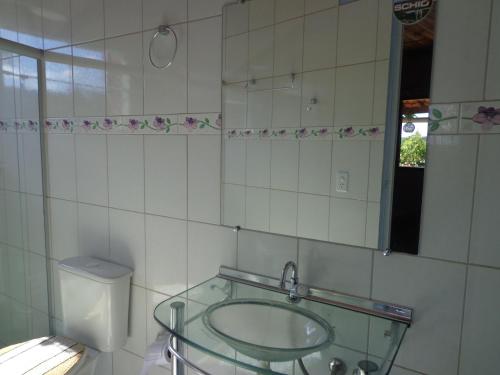 y baño con lavabo de cristal y espejo. en Pousada Recantos dos Mineiros, en Lençóis