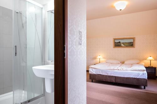 łazienka z łóżkiem, umywalką i prysznicem w obiekcie Hotel Folwark w mieście Zgierz