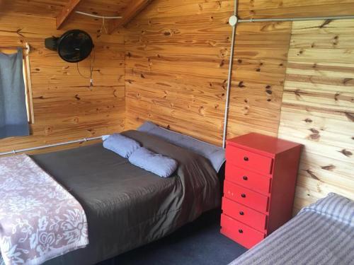 1 dormitorio con 1 cama y vestidor rojo en Carelhue en Epuyén