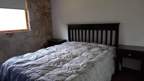 1 cama grande en un dormitorio con ventana en Casa En Acantilados Mar del Plata en Mar del Plata
