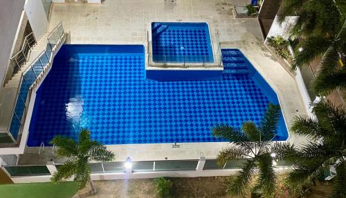 an overhead view of a large swimming pool with blue water at Cozy Apartment with pool in Montería