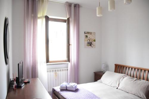 a bedroom with a bed and a desk and a window at La Bouganville in Vitorchiano