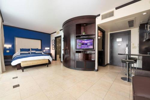 um quarto com uma cama e uma televisão de ecrã plano em Stunning Getaway with Private Outdoor Roman Tub em Miami Beach