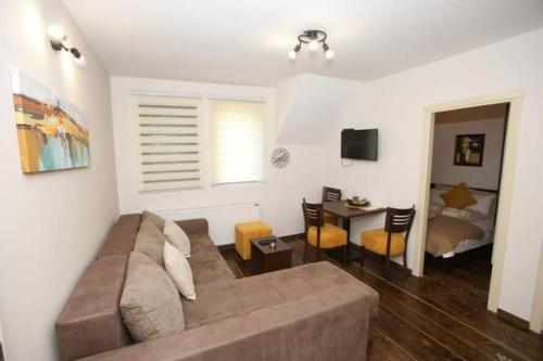 a living room with a couch and a dining room at Apartmani Sunce Stara planina in Crni Vrh