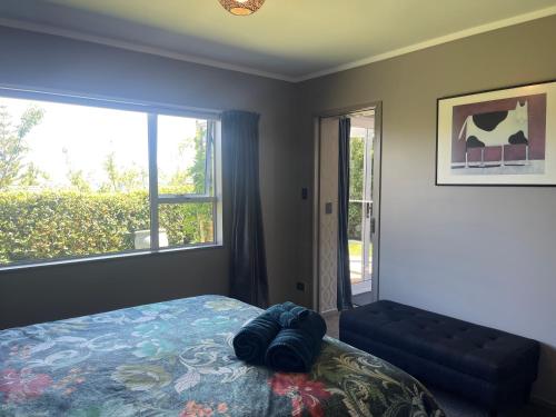 a bedroom with a bed and a large window at The Belfry in Taupo