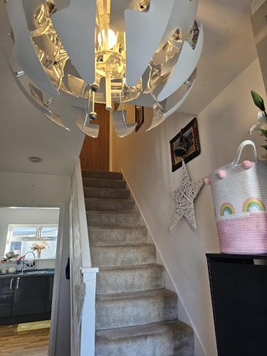 a stairway with a chandelier and a staircase with a staircase at Angle’s Nest in Whitchurch