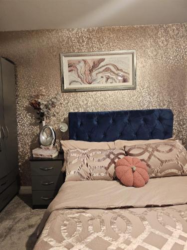 a bedroom with a bed with a blue head board at Angle’s Nest in Whitchurch