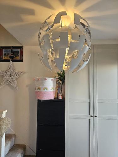 um candelabro pendurado sobre uma cómoda num quarto em Angle’s Nest em Whitchurch