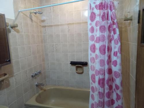 y baño con bañera y cortina de ducha. en Casa La Chacra en Humahuaca