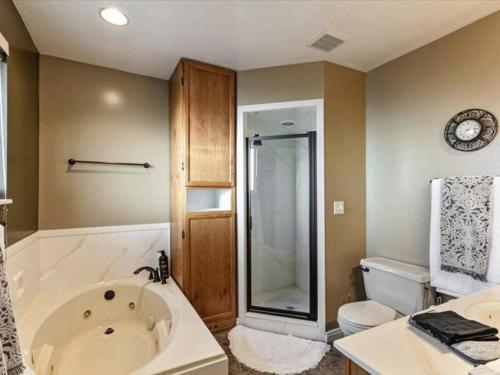 a bathroom with a large tub and a toilet at Close to Mountain View Park King Bed Spacious Yard in Harrisville