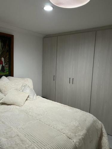 een slaapkamer met een wit bed en een witte kast bij Washington Suite in Barranquilla