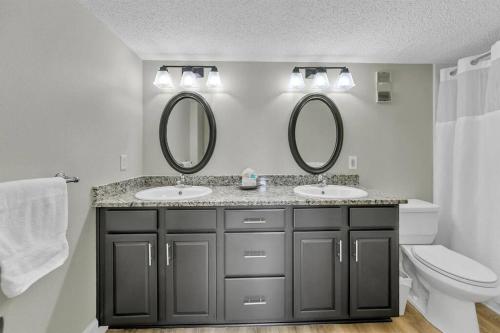 a bathroom with two sinks and two mirrors at Islander 311 Sandy Dunes in Destin