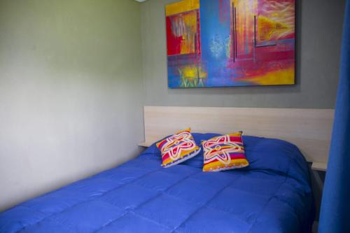 a bedroom with a blue bed with two pillows at La Damasca in Mendoza