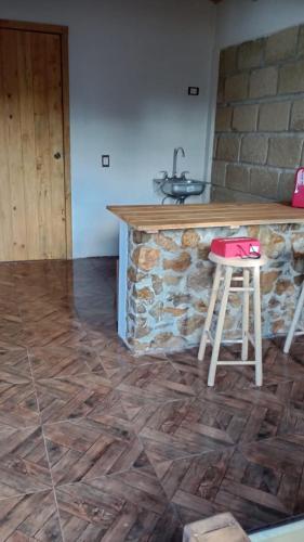eine Küche mit einer Theke, einem Stuhl und einem Waschbecken in der Unterkunft Cabañas Angeles in Huasca de Ocampo