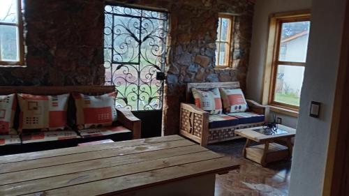 ein Zimmer mit einer Bank und einem Buntglasfenster in der Unterkunft Cabañas Angeles in Huasca de Ocampo