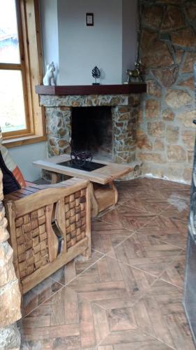 sala de estar con chimenea de piedra y mesa en Cabañas Angeles, en Huasca de Ocampo