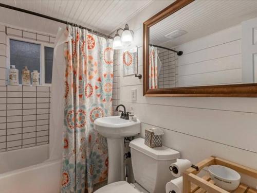 a bathroom with a sink and a toilet and a mirror at Centrally Located in the Heart of Provo 2 BR in Provo