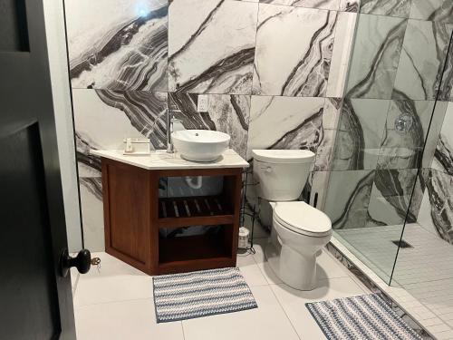 a bathroom with a toilet and a sink at Seaside Escape in Wickhams