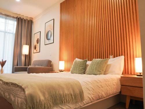 a bedroom with a large bed and a chair at Indiana suites in Mexico City